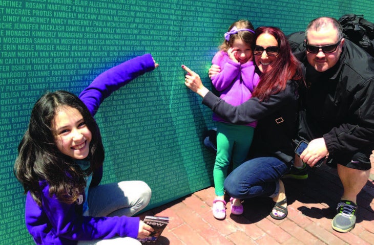 Isabella, Brianna, Lisa and Michael all point out Lisa's name at the Nike race expo.