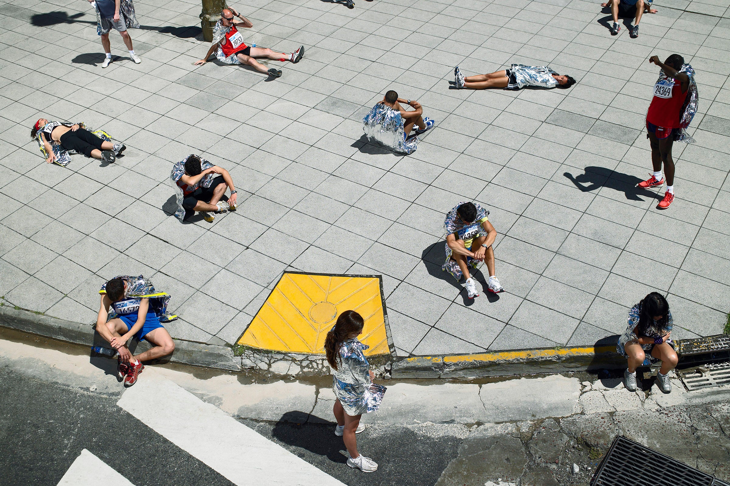 group of runners wearing space blankets for marathon recovery