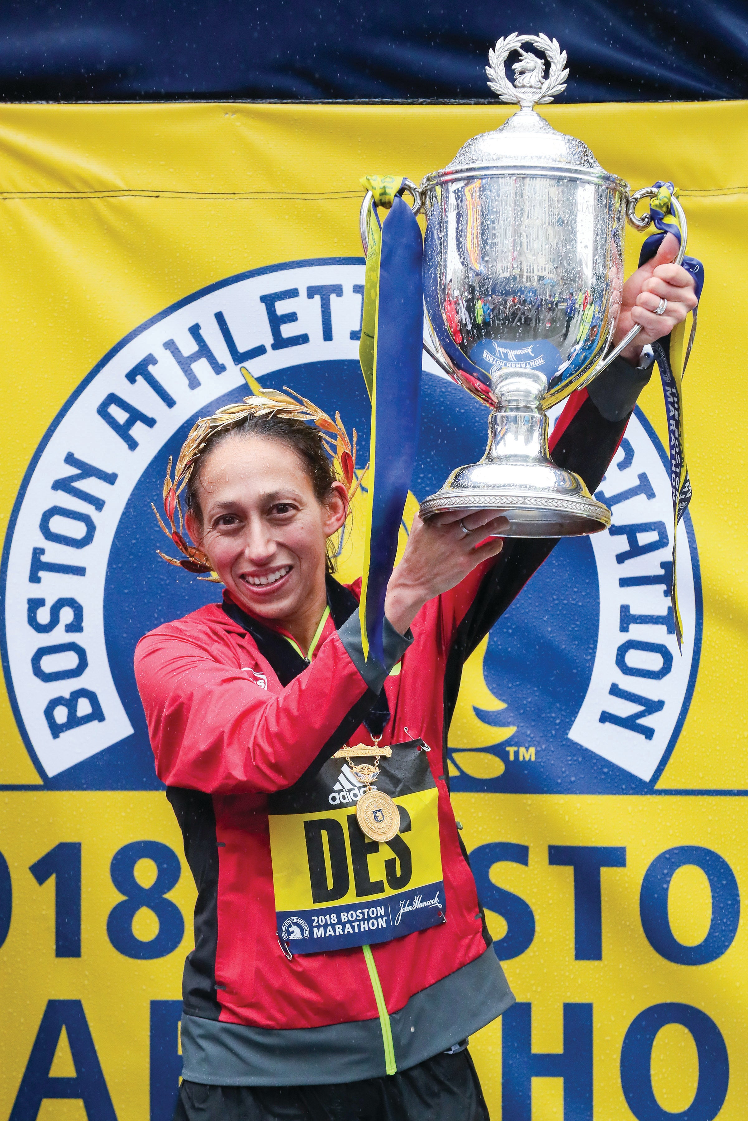 Desiree Linden hoists the winner's trophy at the 2018 Boston marathon. She announced she'll be back for the 2020 Boston Marathon after racing the 2020 Olympic Trials.