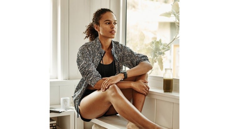 Woman in gray jacket sitting next to a window