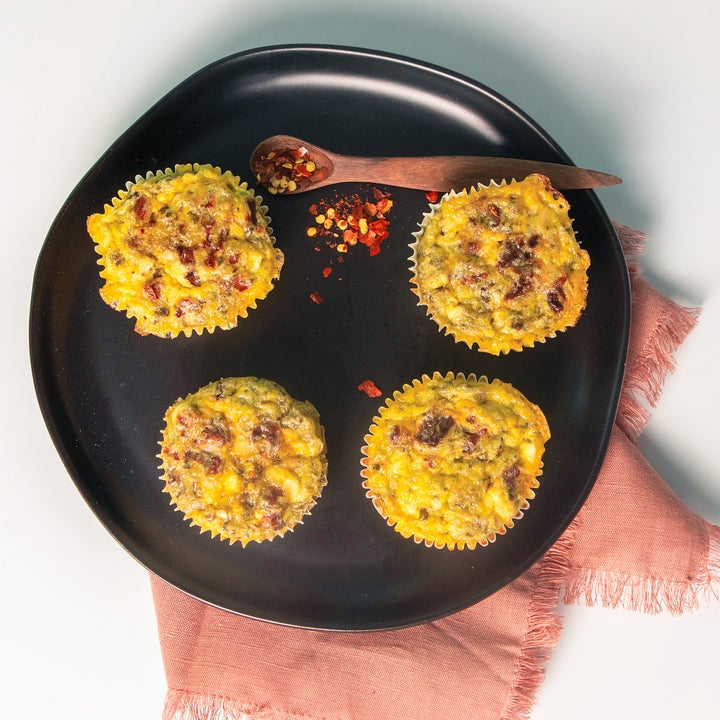 Four egg muffins on a plate with a cloth napkin underneath