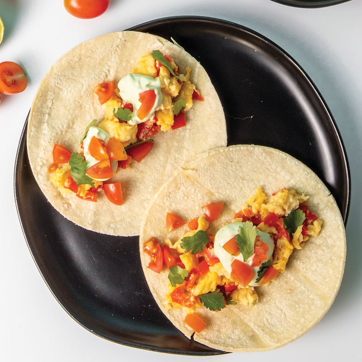 Two egg tacos on a plate with garnish