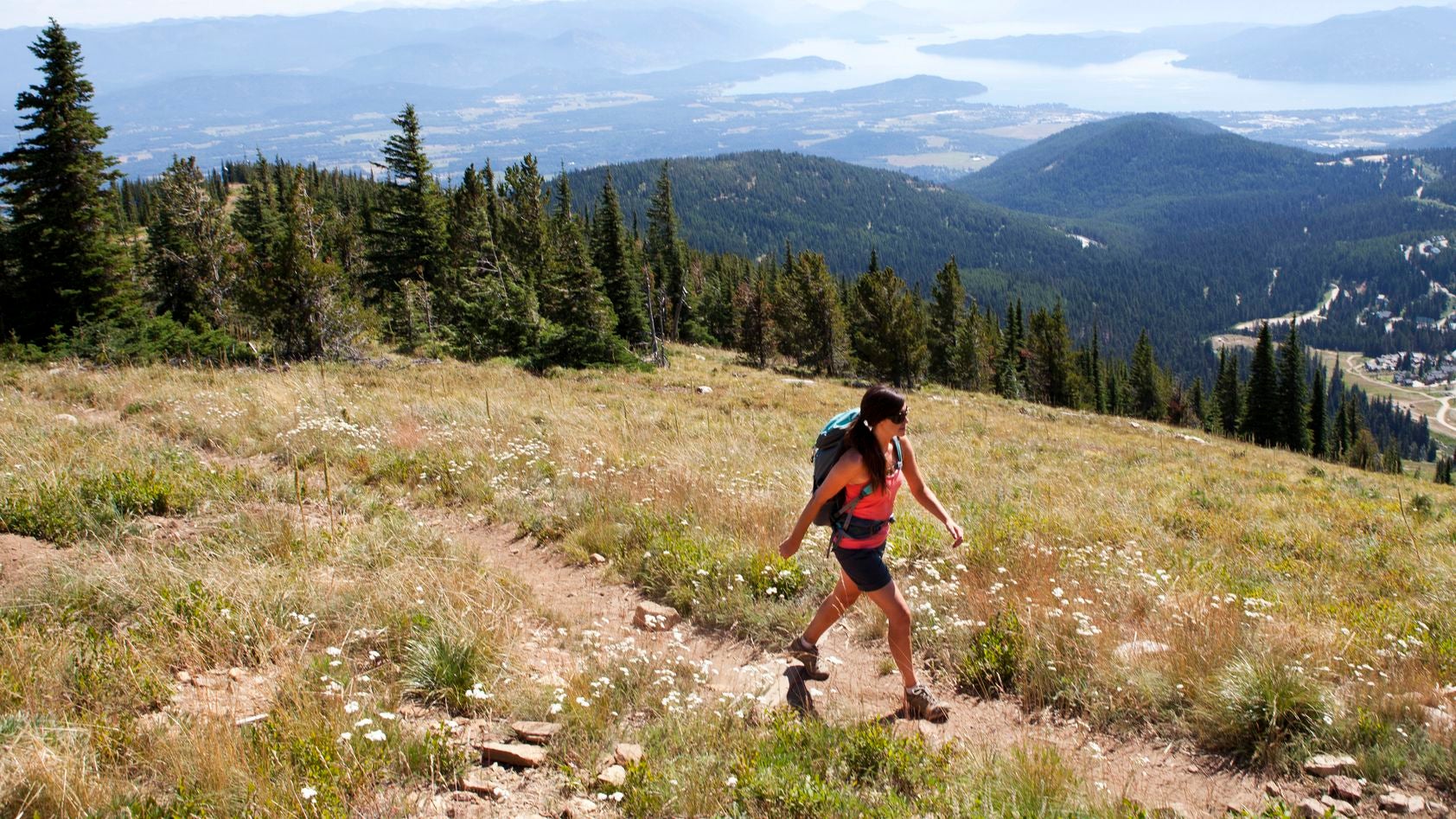 A woman hikes through the mountains on a sunny day