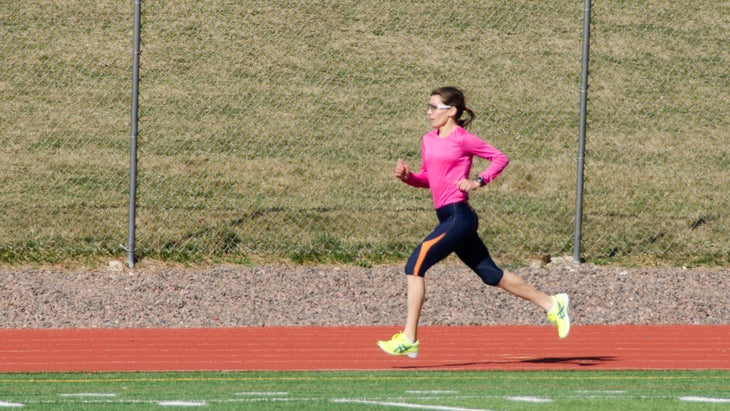 woman running track intervals