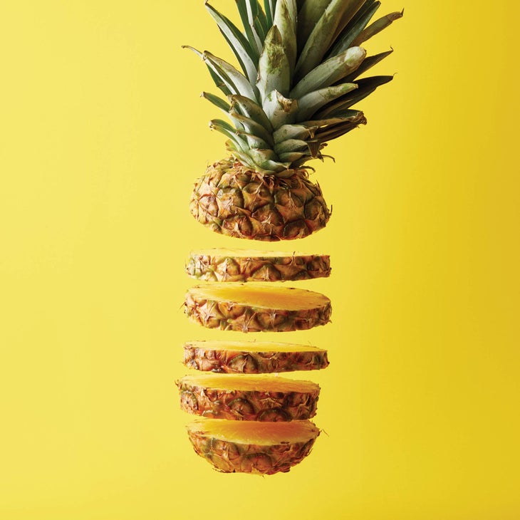 close up view of cut ripe pineapple exotic fruit isolated on yellow