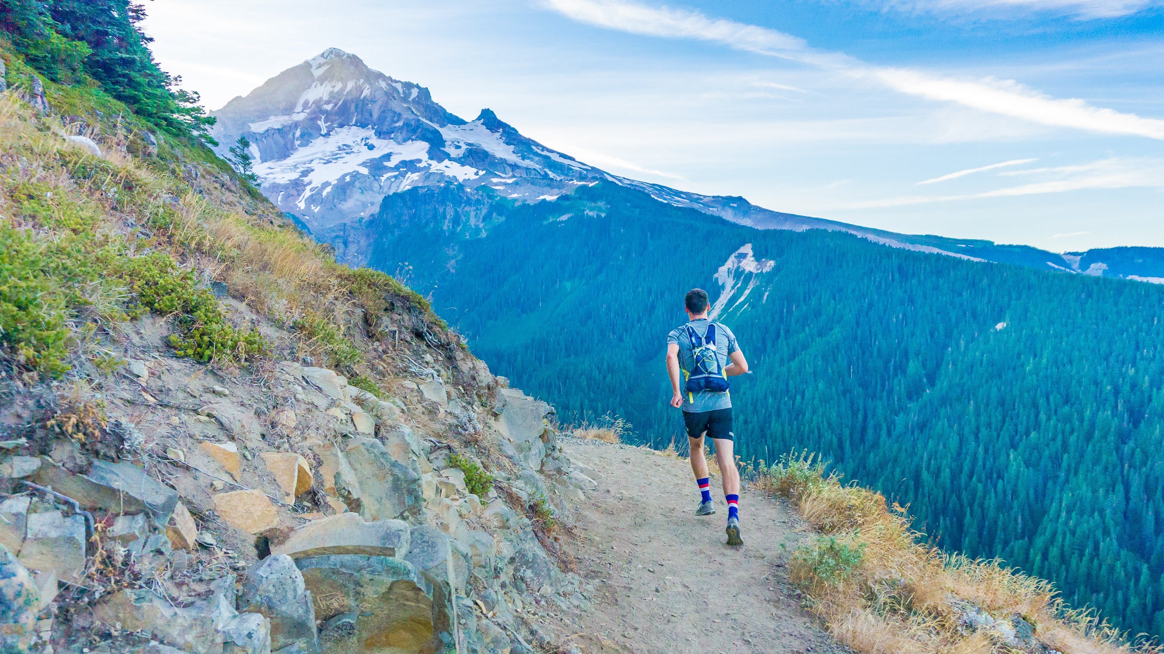 Man running on edge near mountain