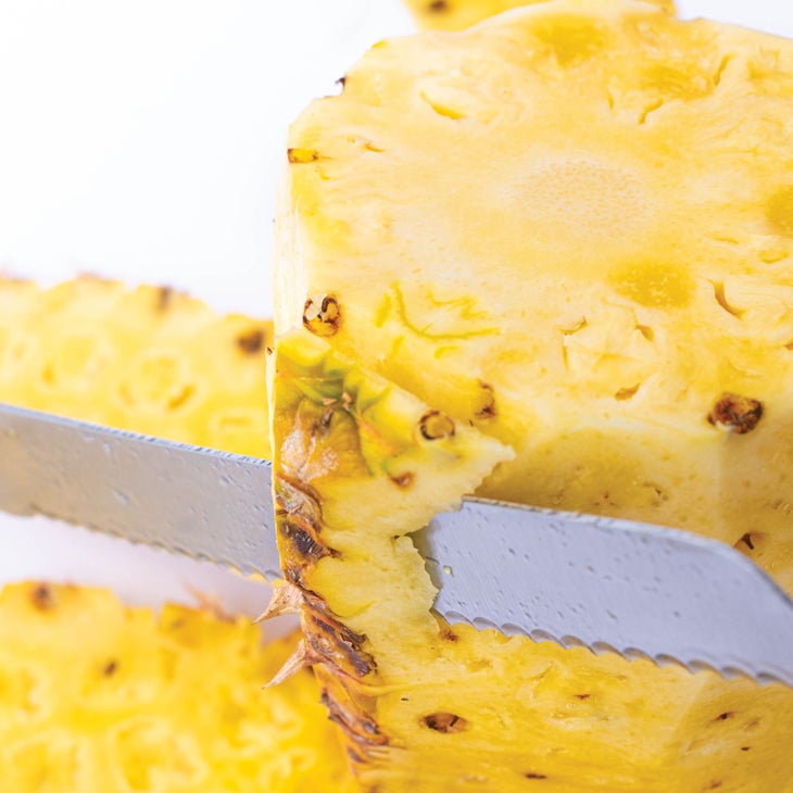 Cutting rind off pineapple