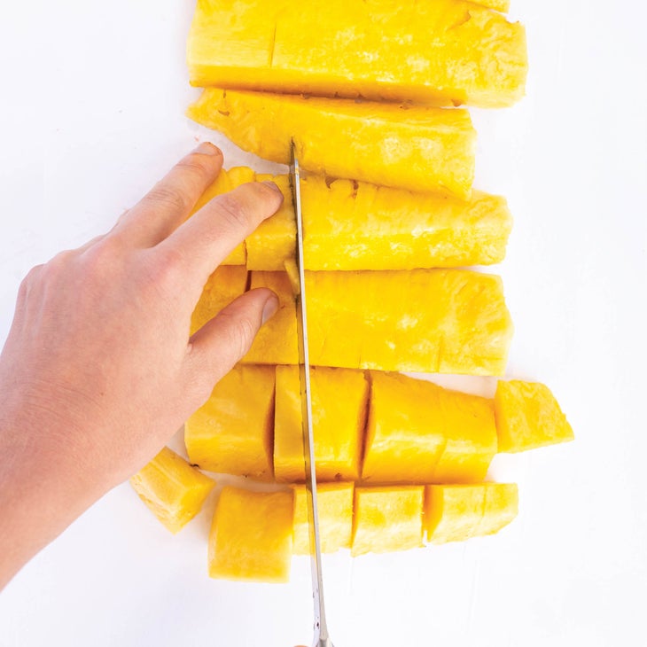 Slicing pineapple into bite-sized pieces