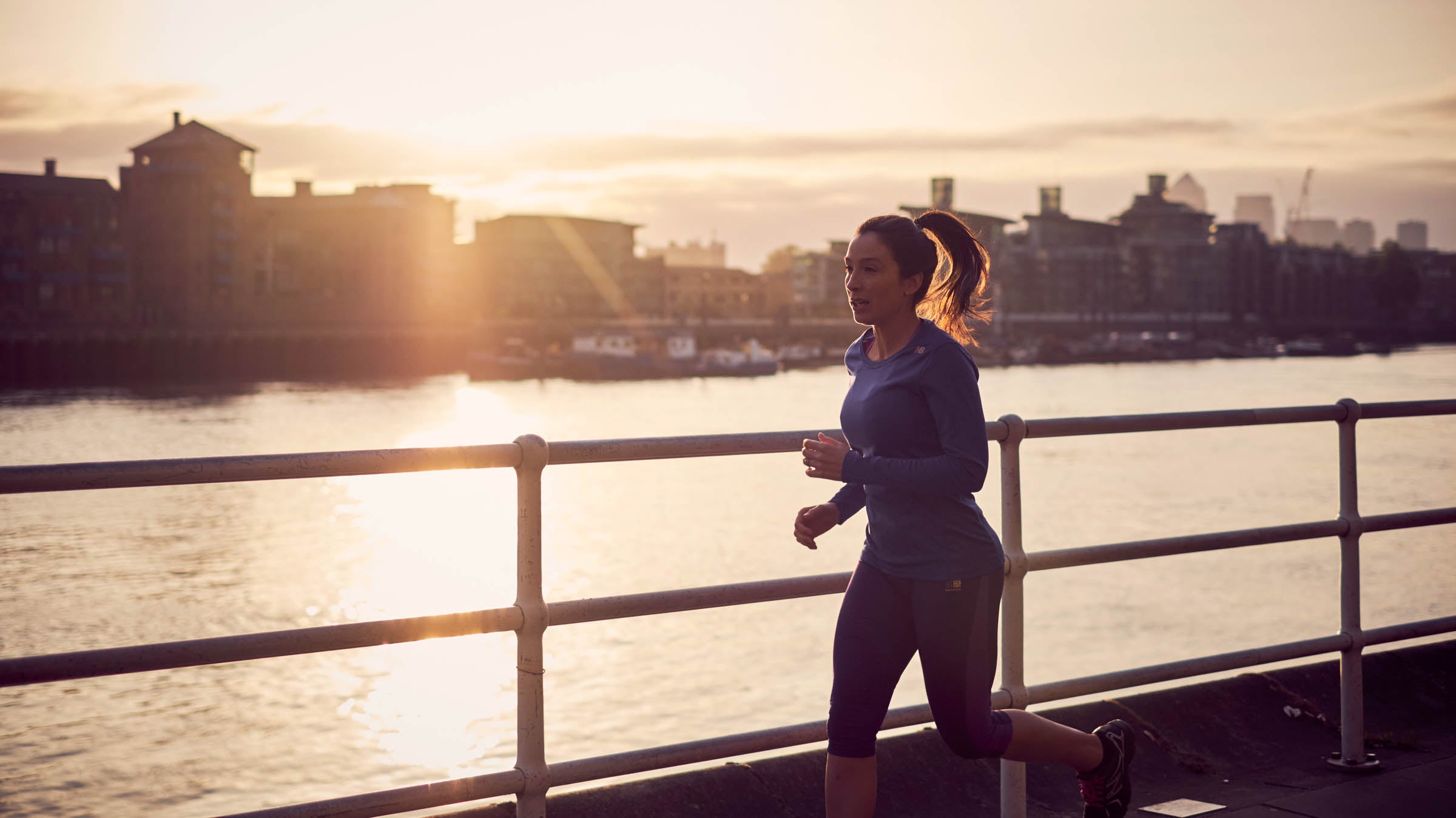 Woman running along an urban waterfront