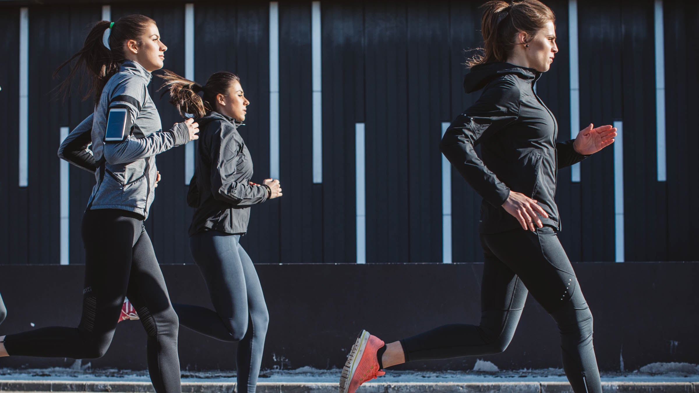 Young men and women running on city streets.