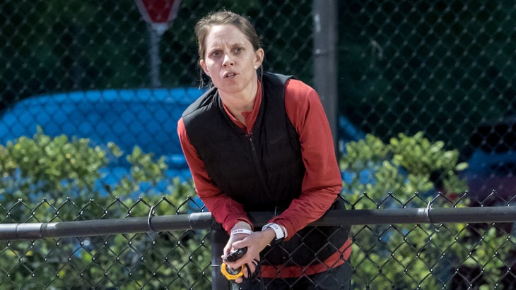 Amy Rudolph leans over a chain-link fence