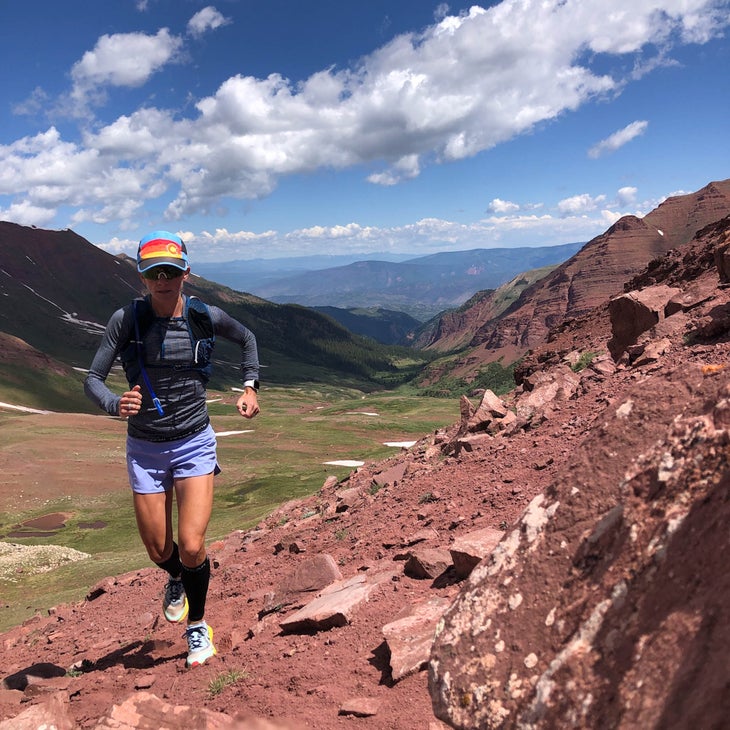 Lizotte running on a red mountainside next to a valley