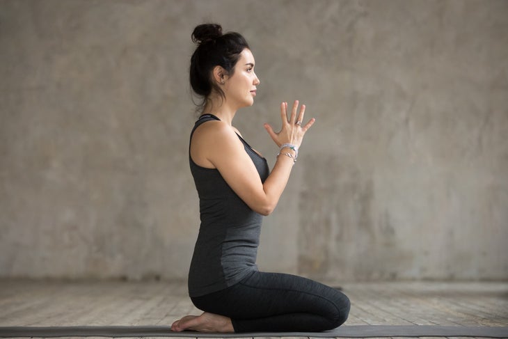 Yogi kneeling on feet in diamond pose.