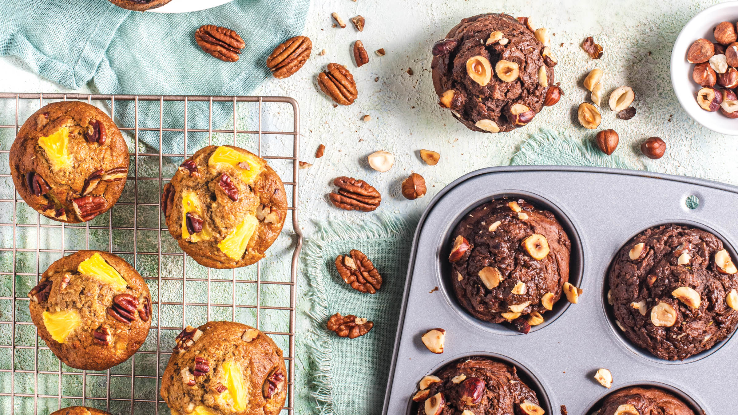 Two batches of muffins on cooling rack and in muffin pan