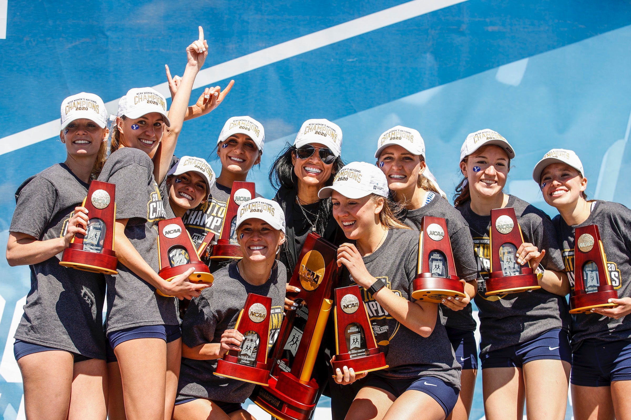 The BYU women's cross country team poses with trophies after winning the team championship during the NCAA Womens Cross Country Championships.