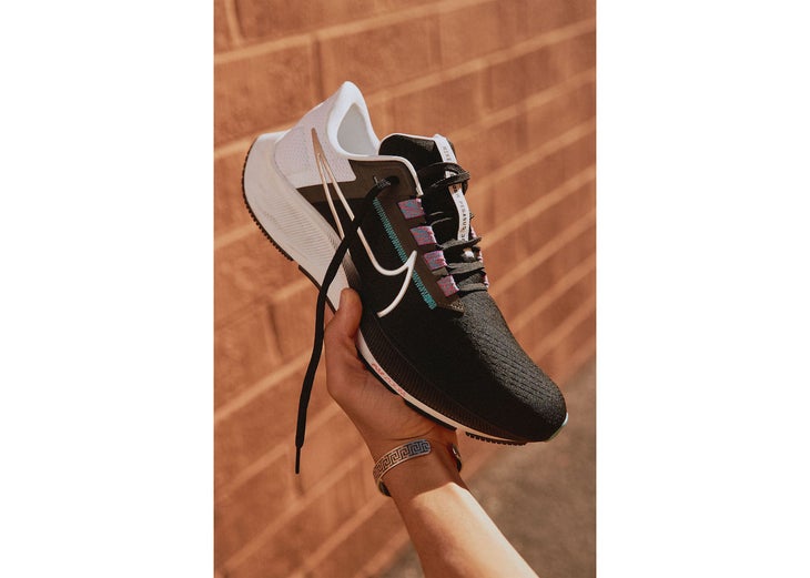 A hand holding the Nike Pegasus 38