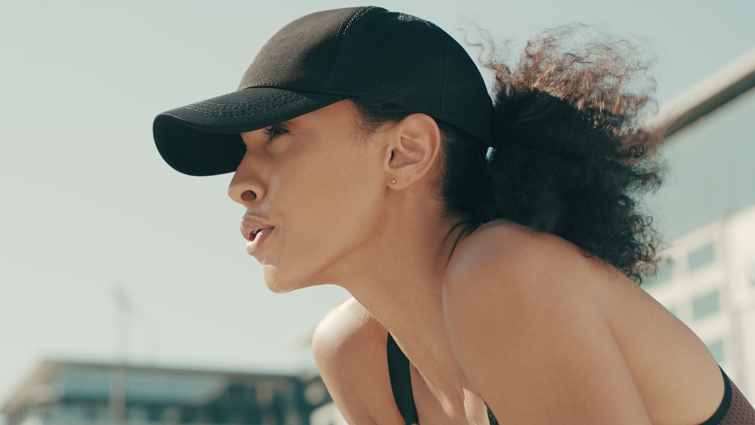 Shot of a sporty young woman catching her breath while exercising in the city