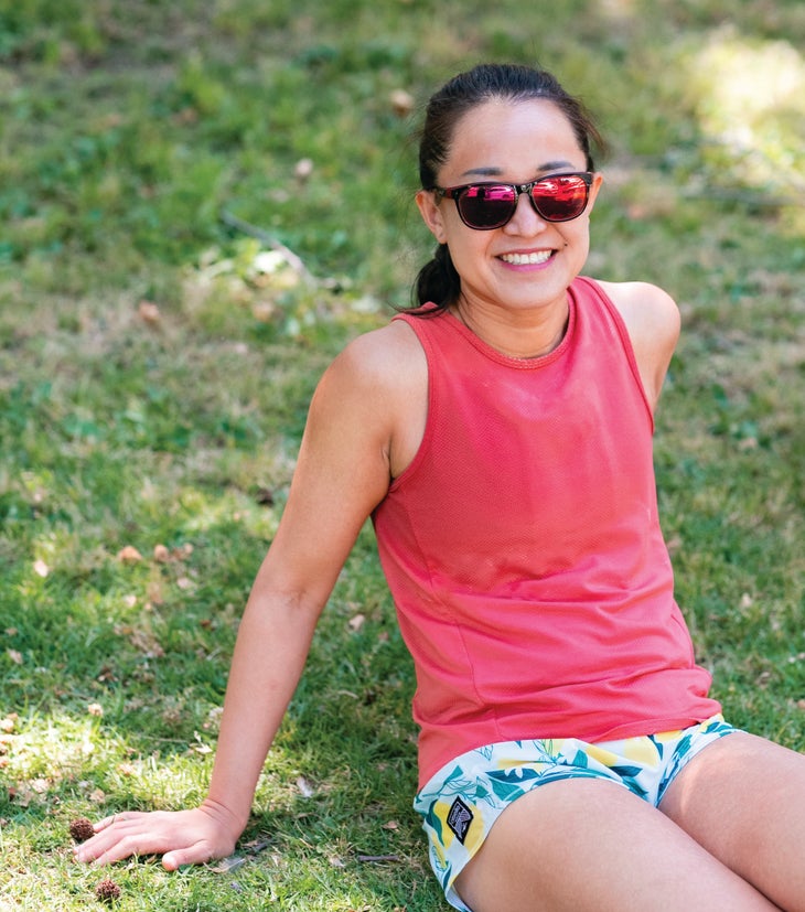 Jinghuan Liu Tervalon smiling, sitting in grass