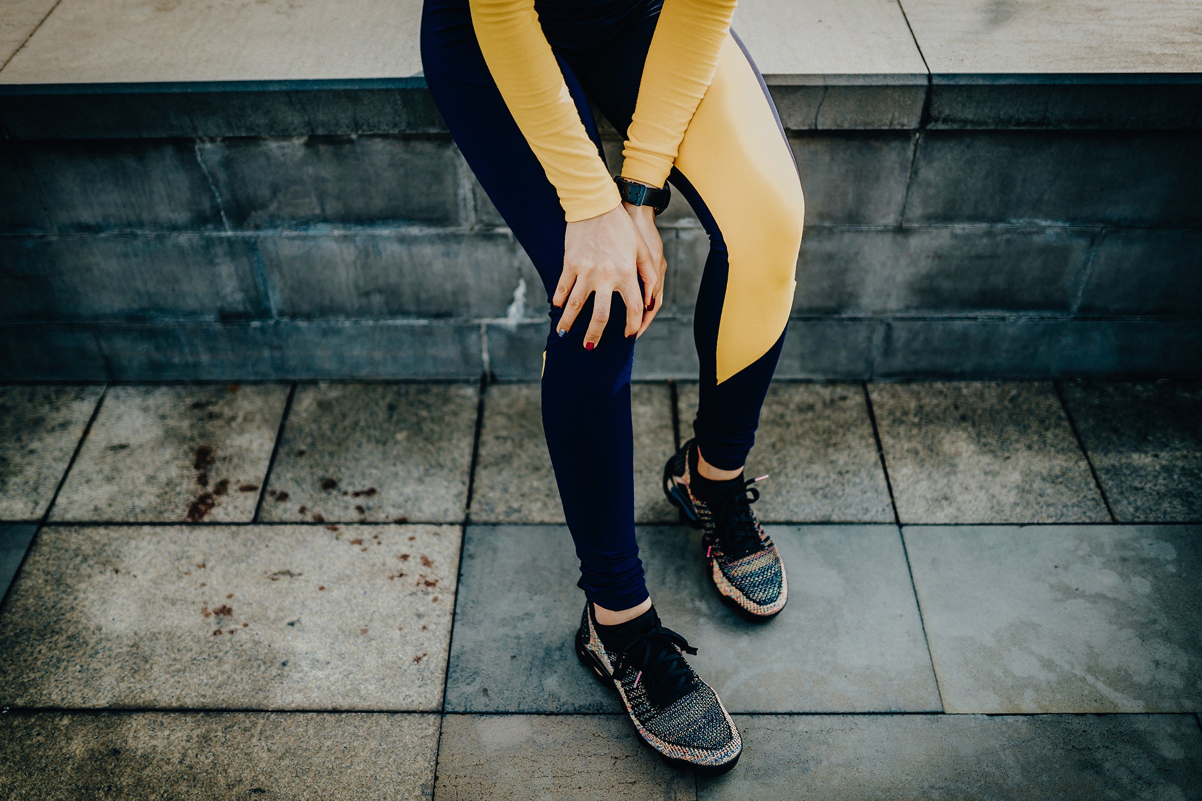 woman grabbing knee in city