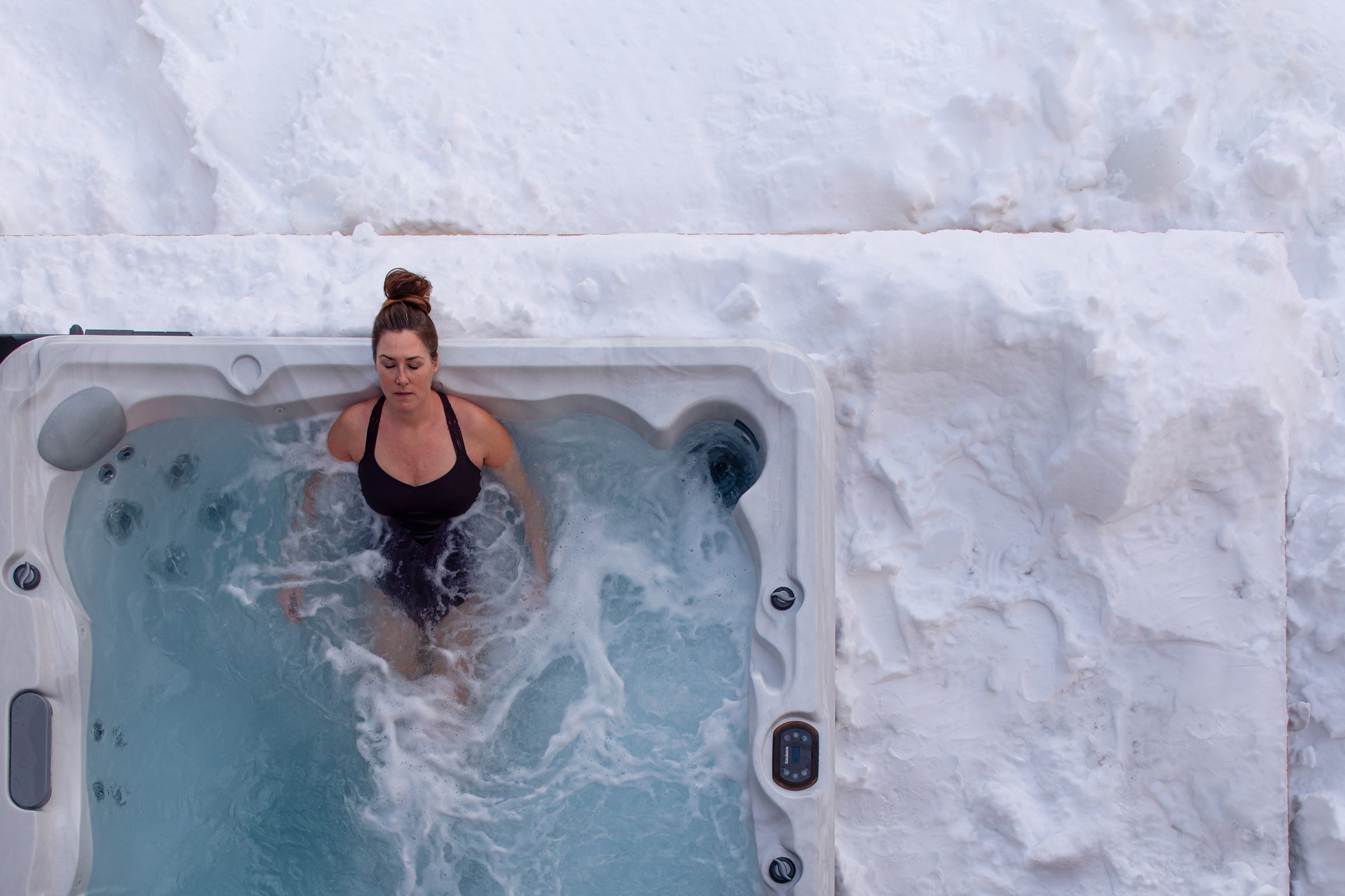 women taking a hot bath surrounded by cold snow after a workout