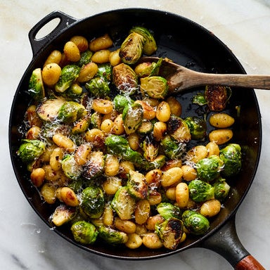 crisp gnocchi and brussels sprouts covered in cheese in a skillet