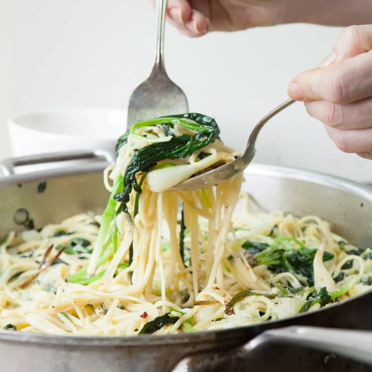 pasta with ramps being spooned from a pot