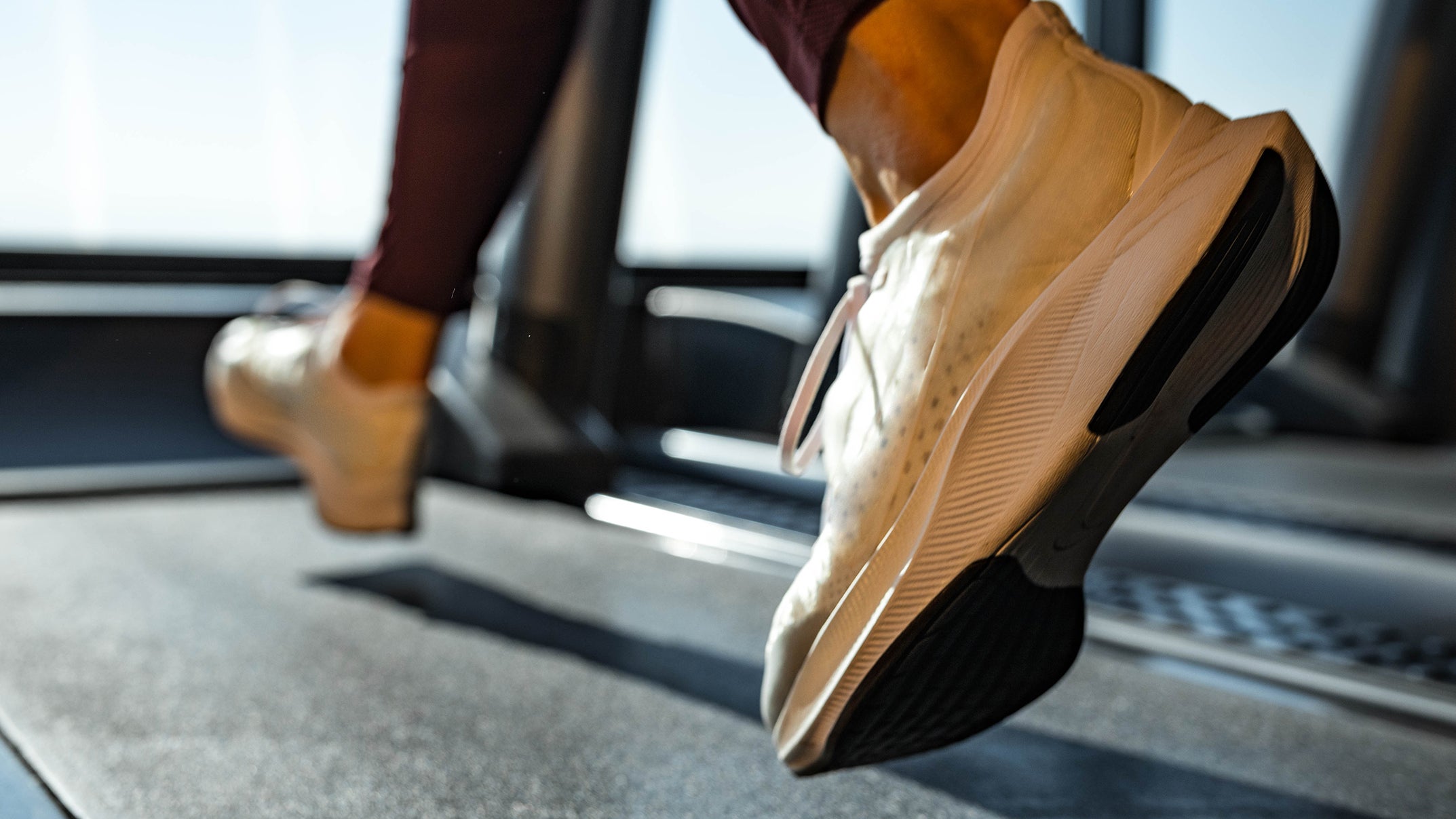 Close up of unrecognizable athletic woman jogging on treadmill, running for weight loss