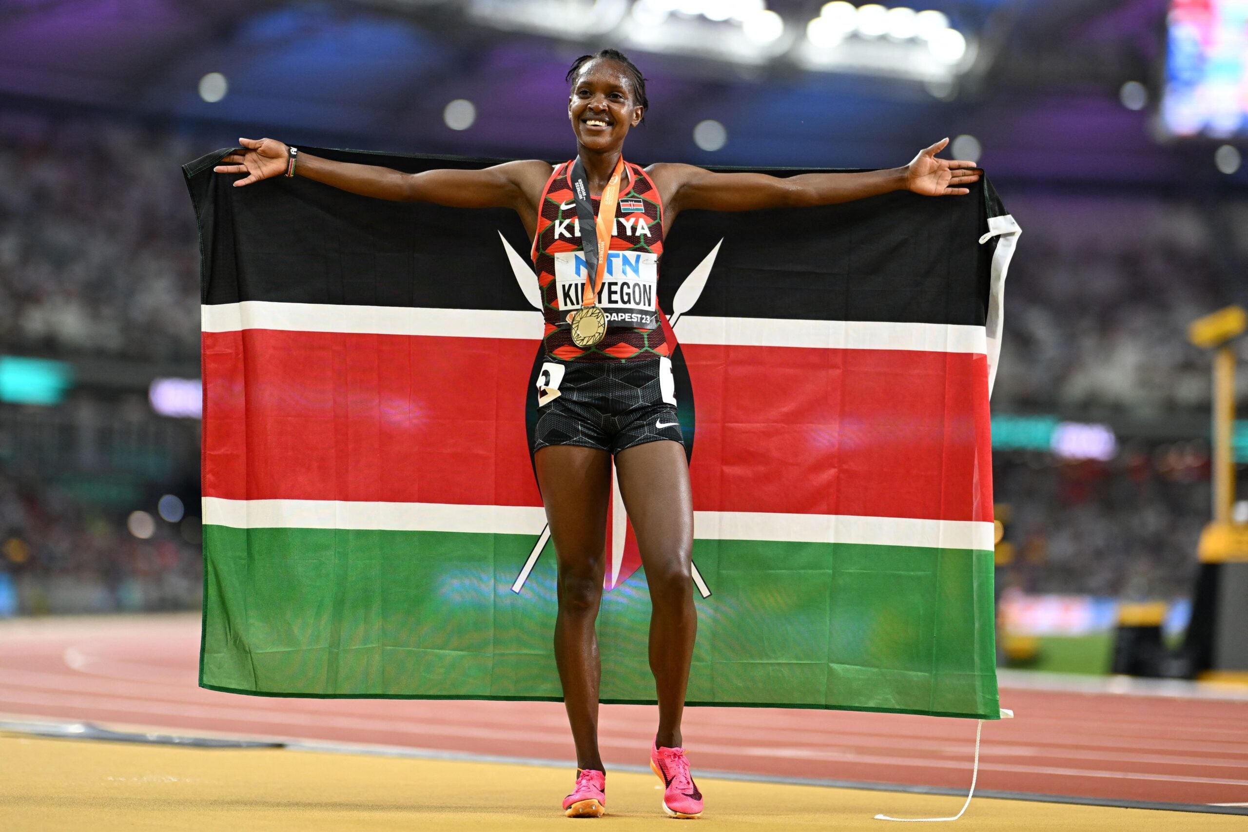 Faith Kipyegon poses with her national flag