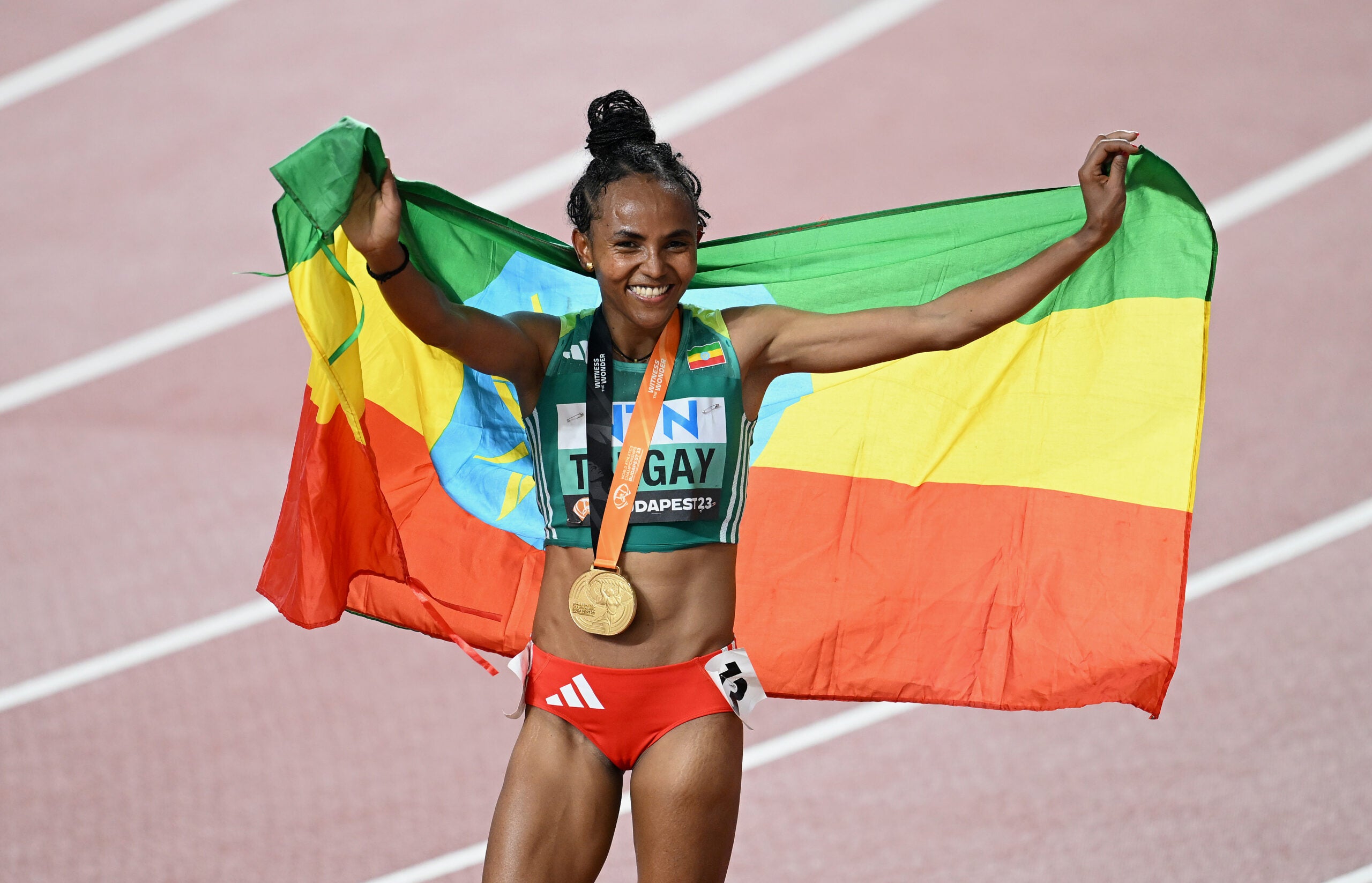 BUDAPEST, HUNGARY - AUGUST 19: Gudaf Tsegay of Team Ethiopia celebrates with a flag and Gold Medal after winning the Women's 10,000m Final during day one of the World Athletics Championships Budapest 2023 at National Athletics Centre on August 19, 2023 in Budapest, Hungary. (Photo by Hannah Peters/Getty Images)