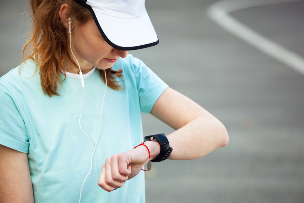 Female runners pauses to check watch