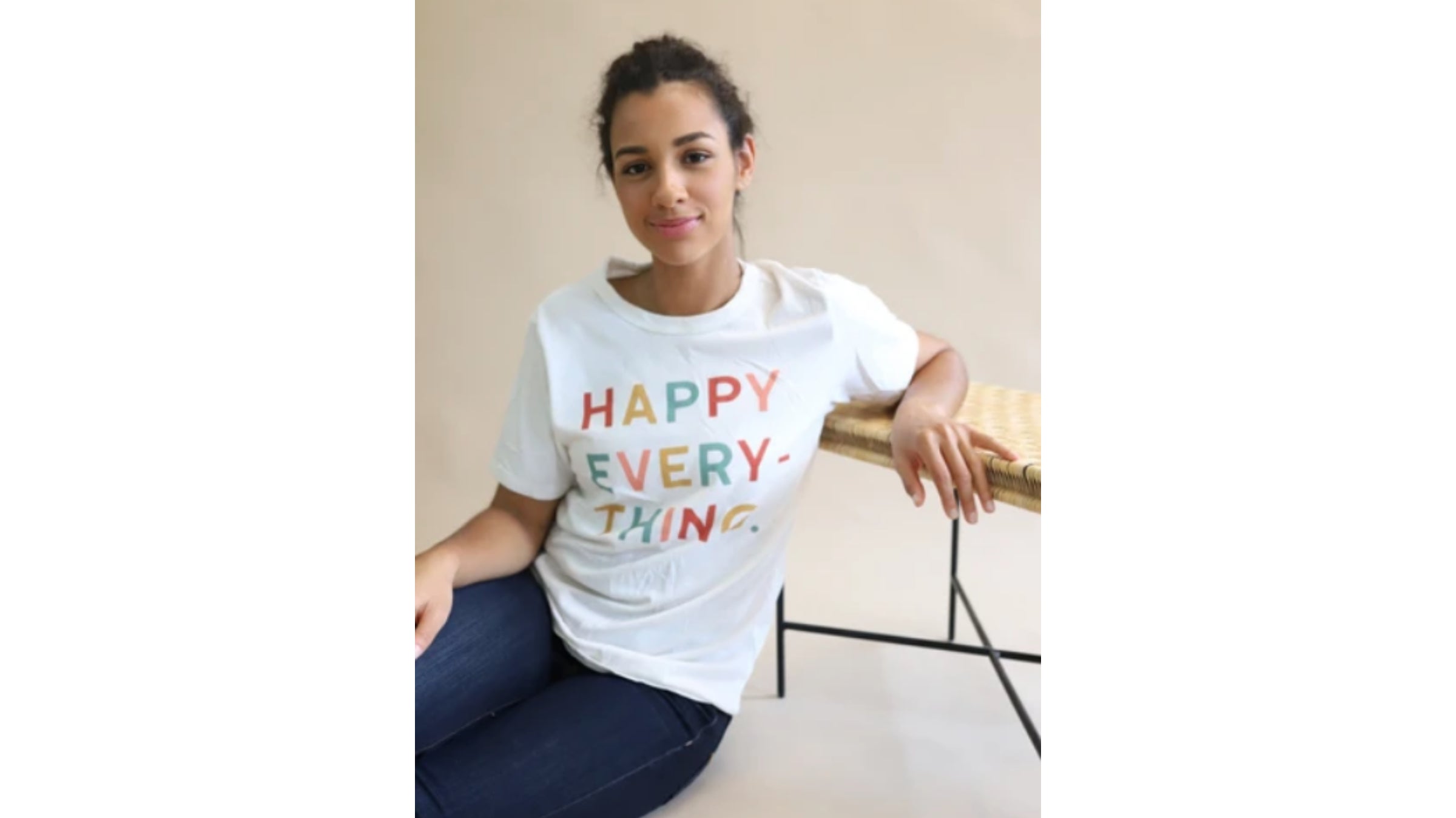 Model wearing white tee with words "happy everything"