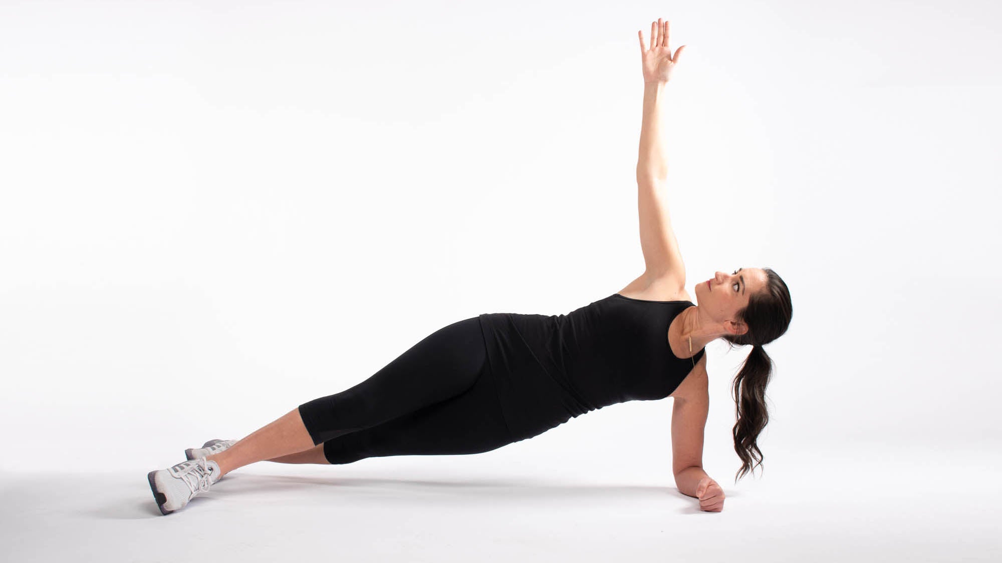 Woman doing side plank on forearm with reach