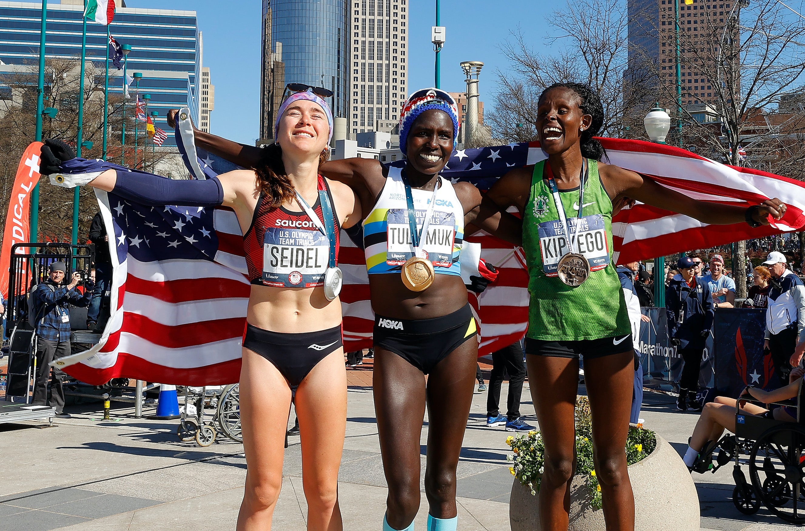 Molly Seidel, Aliphine Tuliamuk, and Sally Kipyego pose after finishing in the top three of the Women's U.S. Olympic marathon team trials on February 29, 2020 in Atlanta, Georgia.