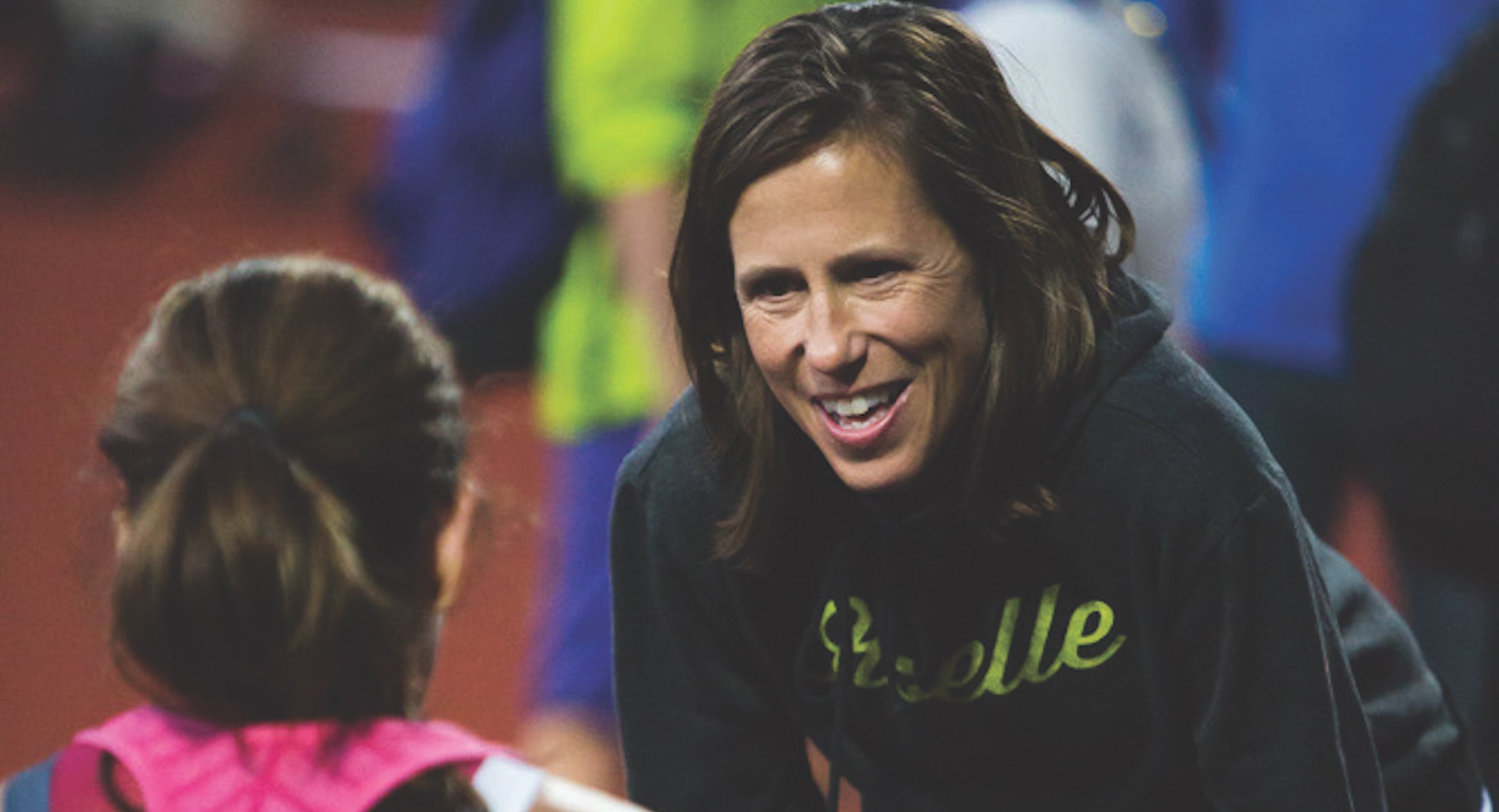 Oiselle CEO Sally Bergesen talks with an athlete during a race