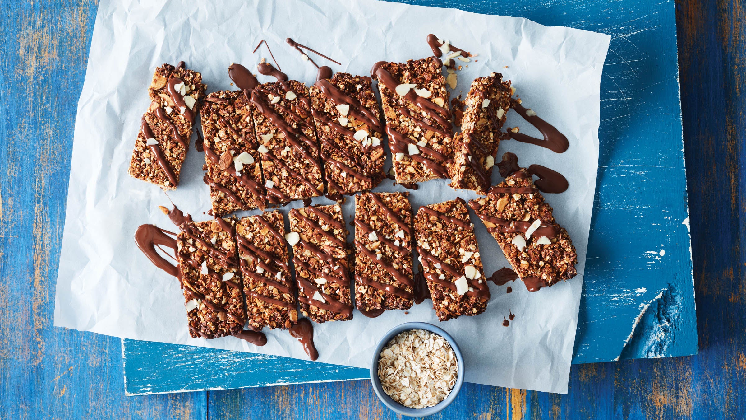 3 recetas para llevar para una energía sostenida AmazingRunning Barras de granola con mantequilla de almendras y chocolate en papel pergamino con llovizna de chocolate hacen una buena receta para el desayuno para llevar